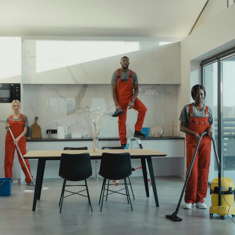 A set of essential home cleaning tools including a vacuum, mop, and brushes